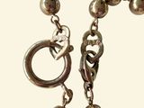 a close up of a chain with a heart on it