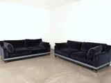 two black couches in a room with a white wall