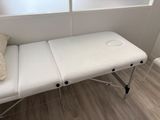 a white table with a pillow on it in front of a window