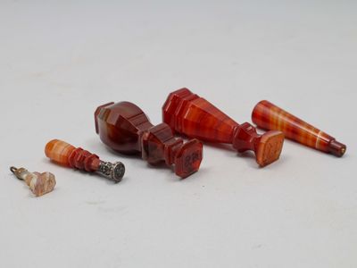 plusieurs morceaux de verre rouge et orange posés sur une surface blanche