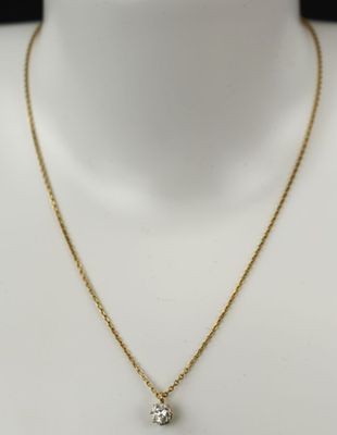 un collier en or avec un pendentif en diamant sur un mannequin
