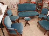 plusieurs chaises et une table dans une pièce avec beaucoup de meubles