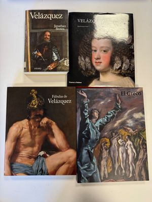 plusieurs livres posés sur une table, à côté d'un tableau représentant un homme coiffé d'un chapeau blanc