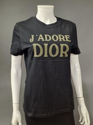 a mannequin wearing a black t - shirt with the word ' adore dior ' on it