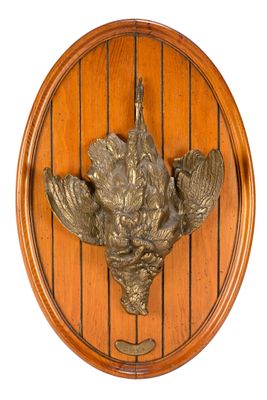 a wooden plaque with a bird on it on a wall