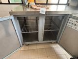 stainless steel counter top in a commercial kitchen with two open doors