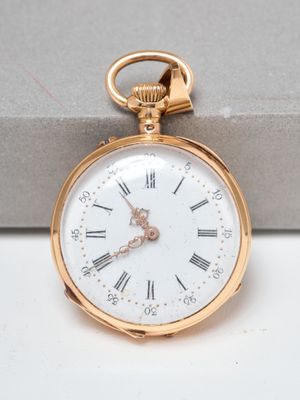 a gold pocket watch with roman numerals on it