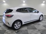 the rear end of a white car in a room with checkered floor