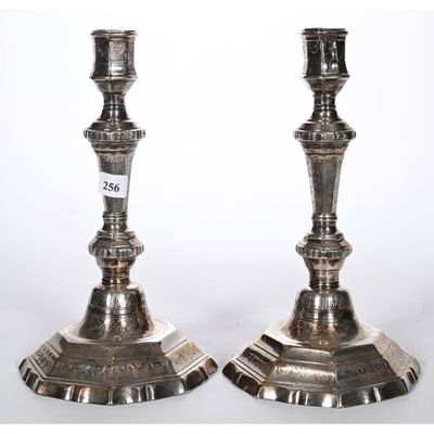 paire de bougeoirs anciens en argent posés sur des socles portant des numéros