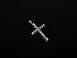 un gros plan d'une croix en diamant sur une surface noire