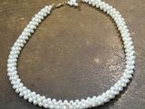 a close up of a white pearl necklace on a table
