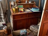 a wooden cabinet in the corner of a room with a sink and a mirror
