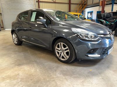 une voiture grise garée dans un garage, avec d'autres voitures en arrière-plan
