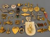 de nombreuses broches en or et en argent posées sur une table