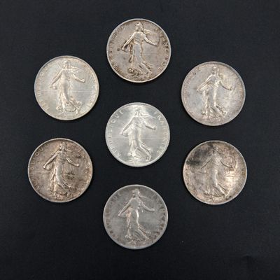 six silver coins are arranged in a circle on a black surface