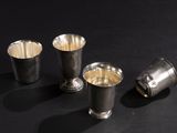 three silver cups sitting next to each other on a black surface