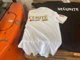 deux t-shirts sur une palette à côté d'un kayak