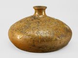 a brown vase that is sitting on a white surface