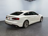 the rear end of a white audi sedan parked in a garage