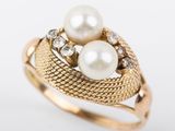 un gros plan d'une bague en or ornée de deux perles et de diamants