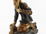 figurine of an old man sitting on a rock with a dog