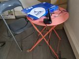 une petite table sur laquelle est posé un téléphone portable, à côté d'une chaise