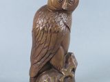 wooden owl figurine sitting on top of a tree stump