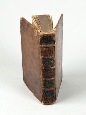 un vieux livre ouvert sur une surface blanche