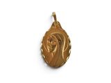a close up of a gold pendant on a white surface