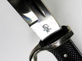 a close up of a knife on a white surface