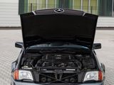 a car with its hood open sitting on a brick driveway