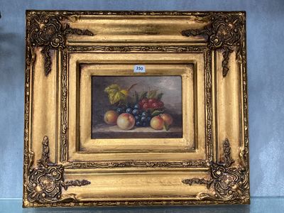 tableau représentant une nature morte aux fruits, dans un cadre doré, accroché à un mur bleu