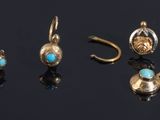 five pairs of gold and turquoise stone earrings on a black surface
