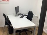 a white table with a computer on it in a room