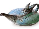 une théière bleue et verte ornée d'un oiseau