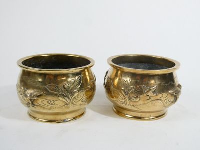 two gold vases sitting next to each other on a white surface