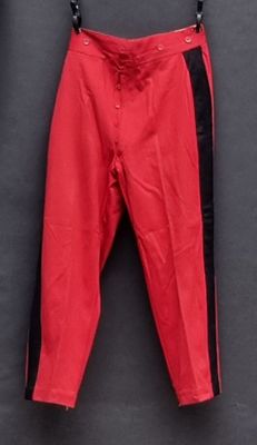 une photo d'un pantalon rouge suspendu à une corde à linge