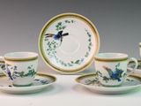 five cups and a saucer with a bird on them