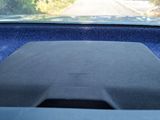 a car dashboard with a blue carpet and a black dash mat