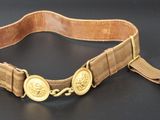 ceinture en cuir marron avec des boutons dorés sur fond noir