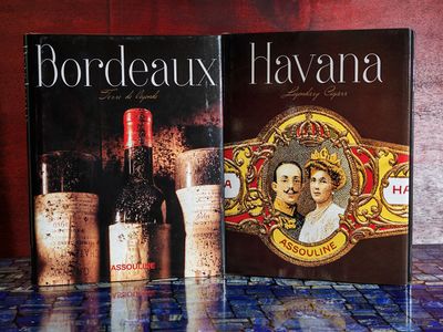 deux livres posés sur une table, à côté d'une bouteille de vin