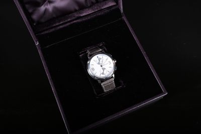une montre posée dans une boîte noire sur une surface noire