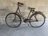 a old bicycle that is leaning against a wall