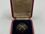 une petite boîte rouge contenant une médaille en argent et en or