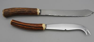 two knives with wooden handles sitting on top of a table