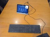a tablet computer and a keyboard on a wooden table