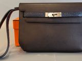 une boîte orange et noire sur laquelle est posée une sacoche noire