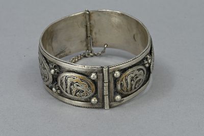 an antique silver bracelet with a design on the side