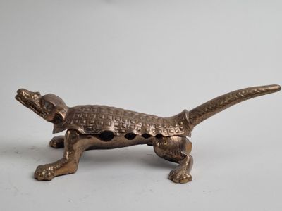 brass figurine of a lizard on a white background