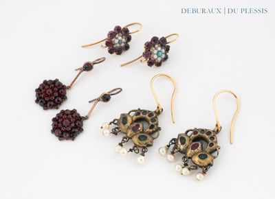 four pairs of earrings with pearls and garnets on a white surface